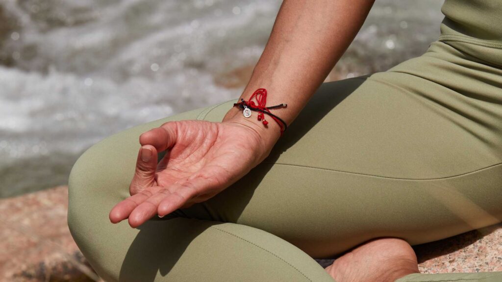 Femme qui médite sur la plage en plein air avec un legging vert kaki